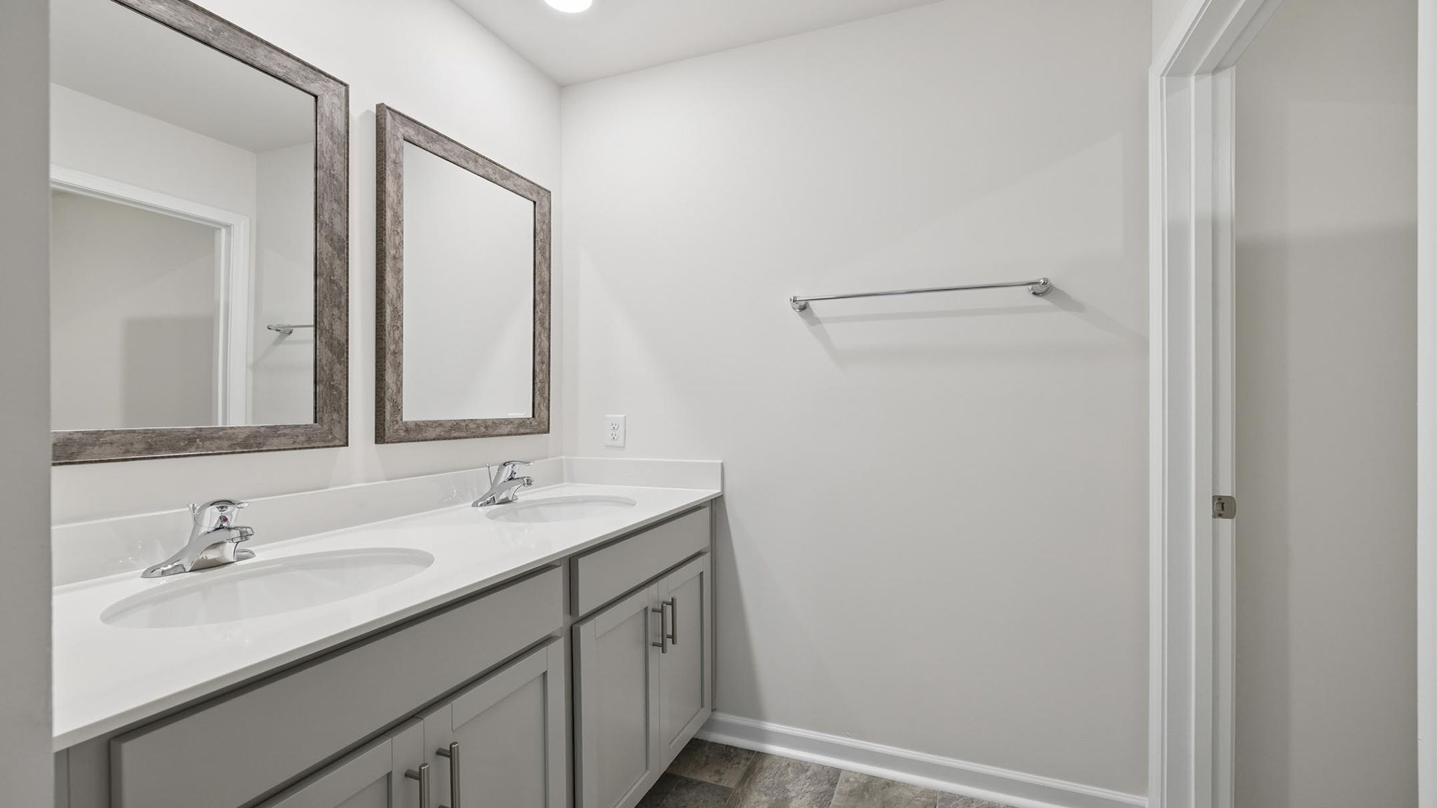 Hall bathroom with dual sink vanity and combination shower / tub.