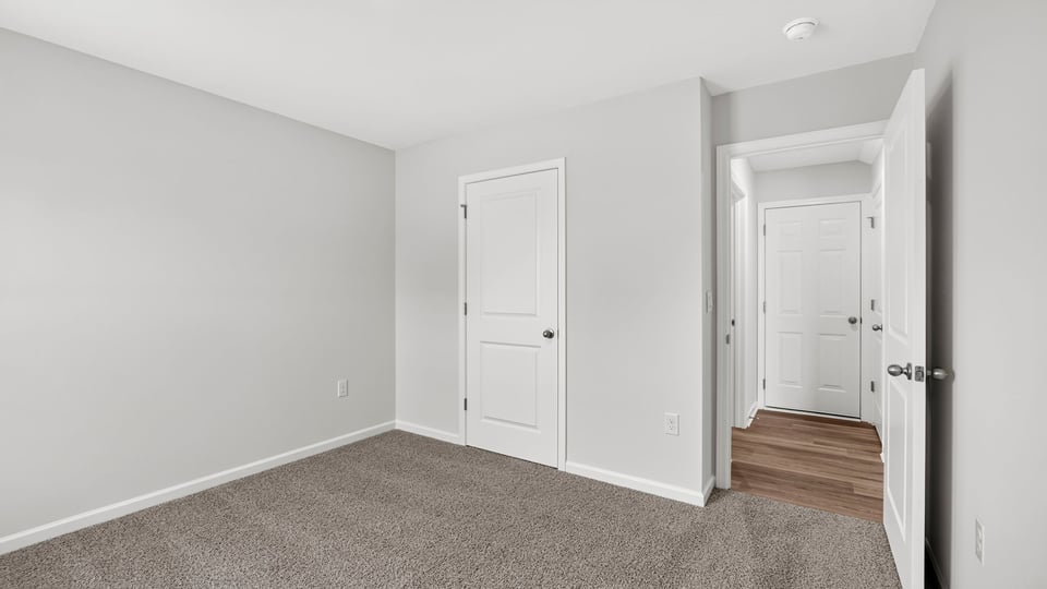 Bedroom with carpet and windows.
