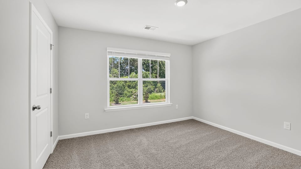 Bedroom with carpet and window.