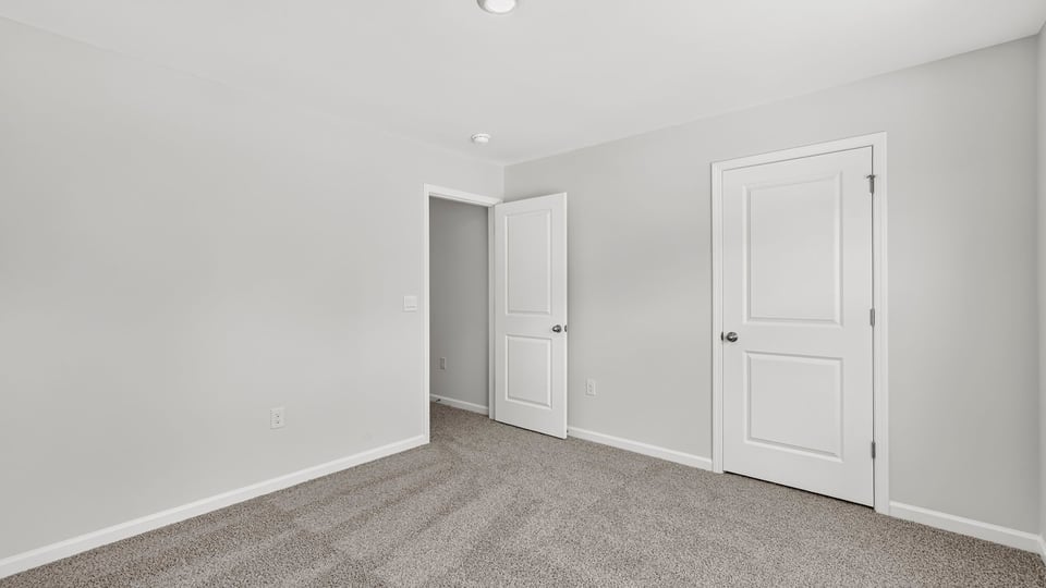 Bedroom with carpet and window.