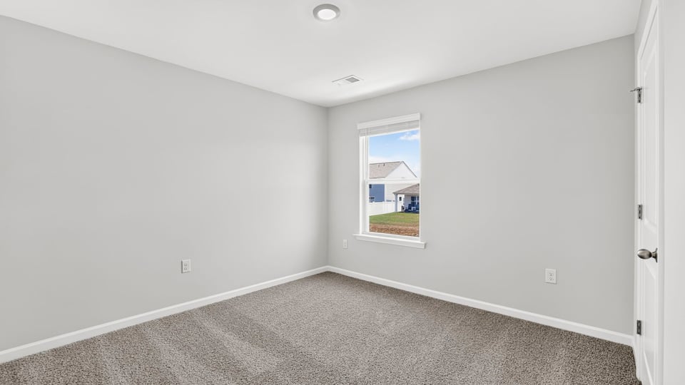 Bedroom with carpet and window.