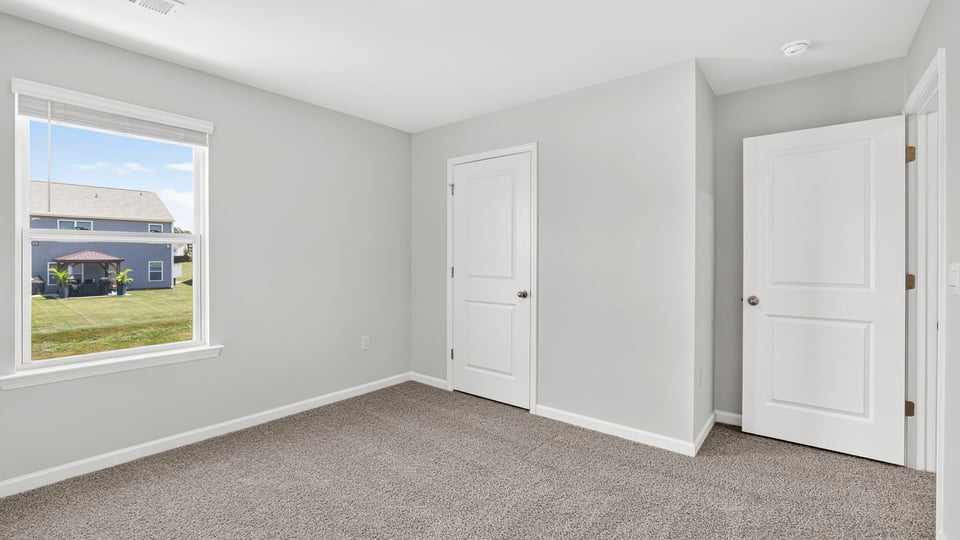 Bedroom with carpet and window.