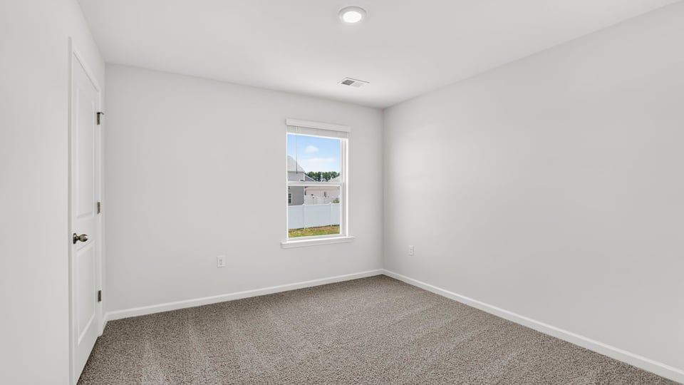 Bedroom with carpet and window.