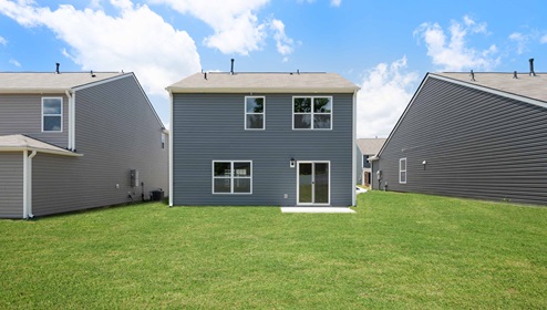 Back exterior of home with large backyard.