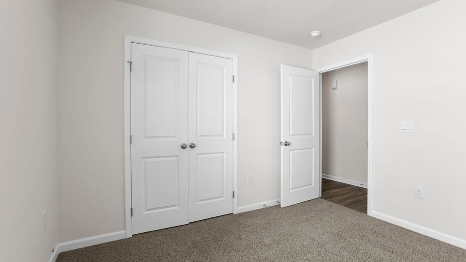 Bedroom with carpet and window.