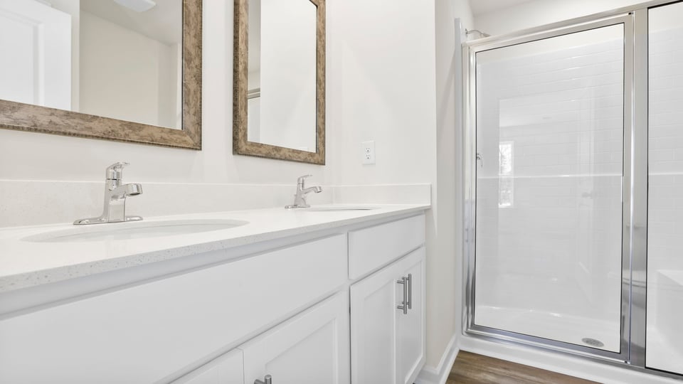 Bathroom with double vanity sink and shower.