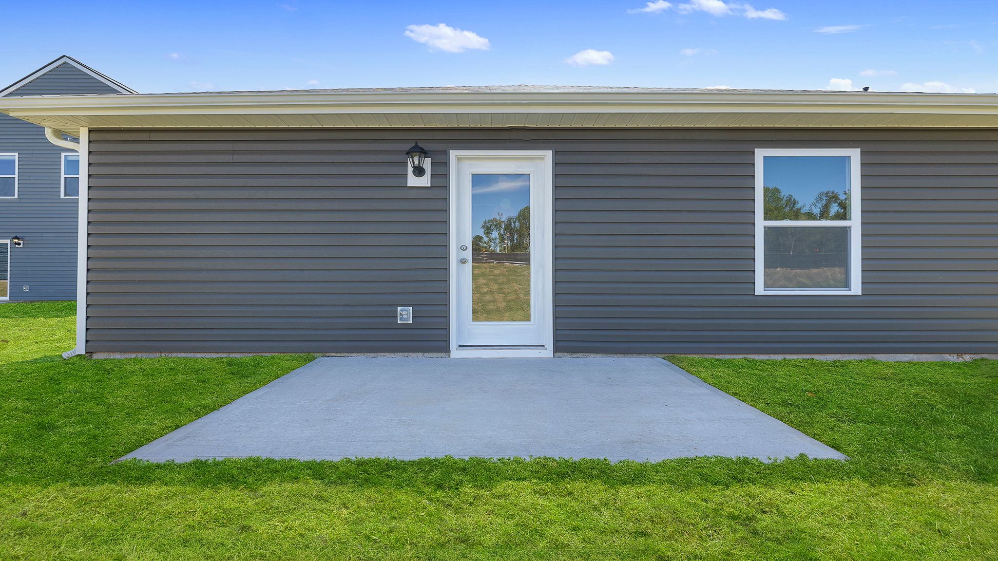 Back of home with patio and large backyard.