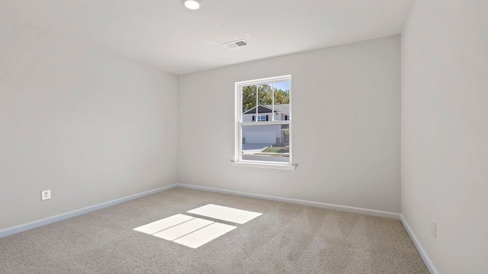 Bedroom with carpet and windows.