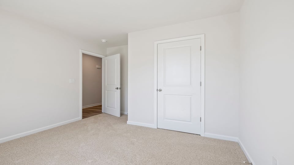 Bedroom with carpet and windows.