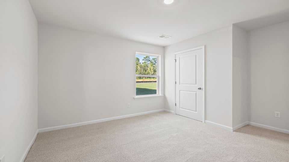 Bedroom with carpet and windows.