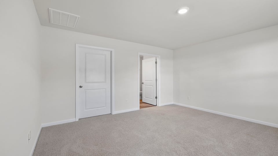 Bedroom with carpet and windows.