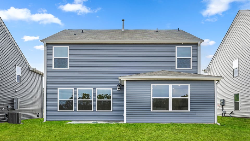 Back exterior of home with large backyard.