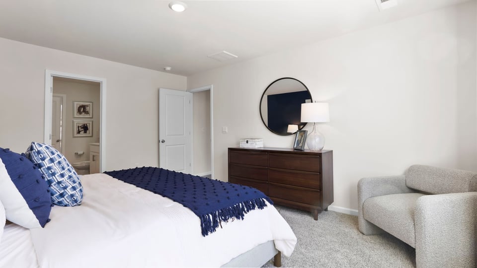 Primary bedroom with window and carpet.