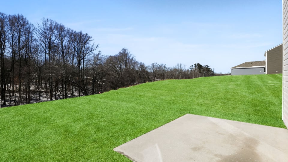 Back exterior with large backyard and patio.