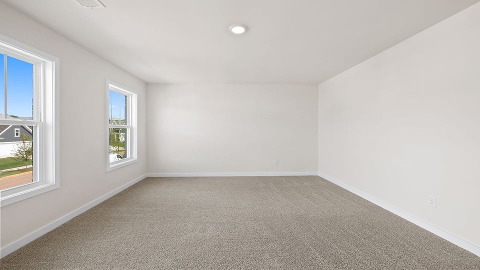 Bedroom with carpet and windows.