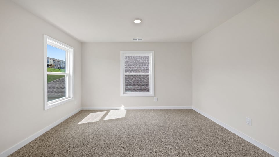 Bedroom with carpet and windows.