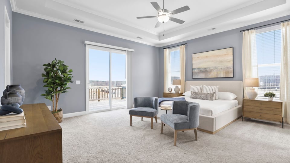 Primary bedroom with large windows and carpet.
