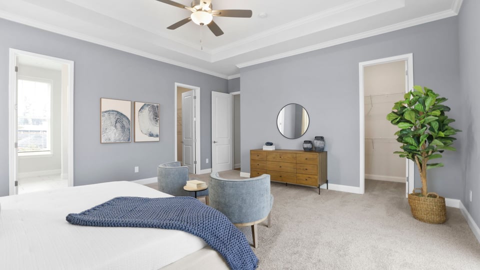 Primary bedroom with large windows and carpet.