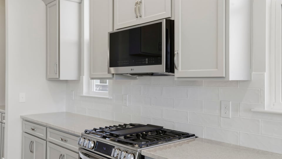 Kitchen with quartz countertops and stainless steel appliances.