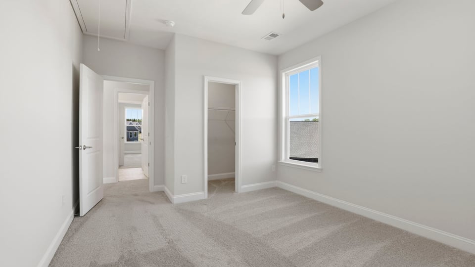 Bedroom with carpet and window.