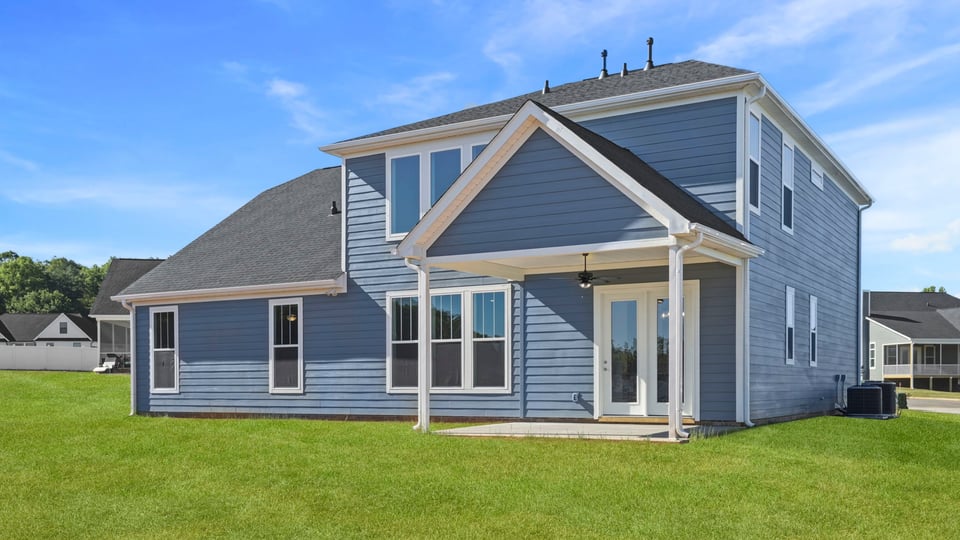 Back exterior of home with large backyard.