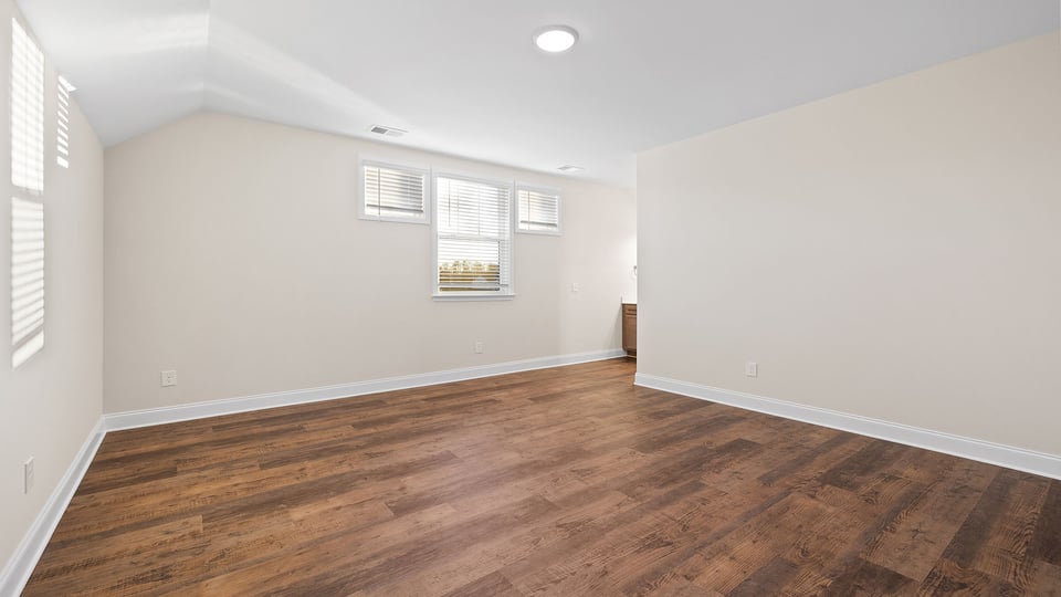 Bedroom of home with windows.