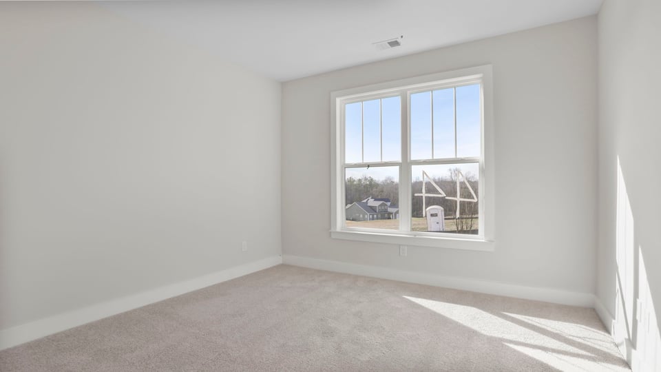 Bedroom with carpet and window.