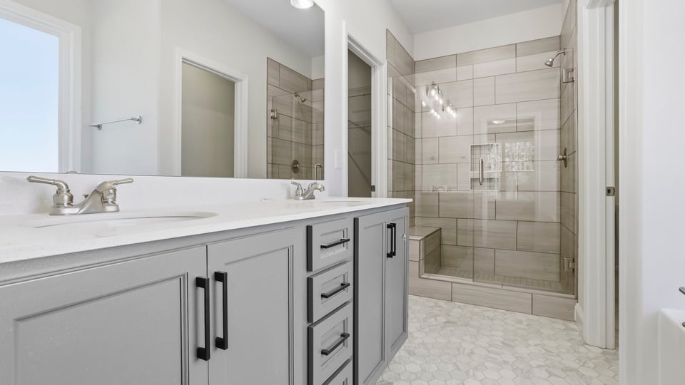 Bathroom with double vanity sink and shower.