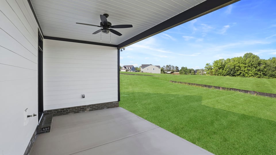 Back exterior of home with covered patio.