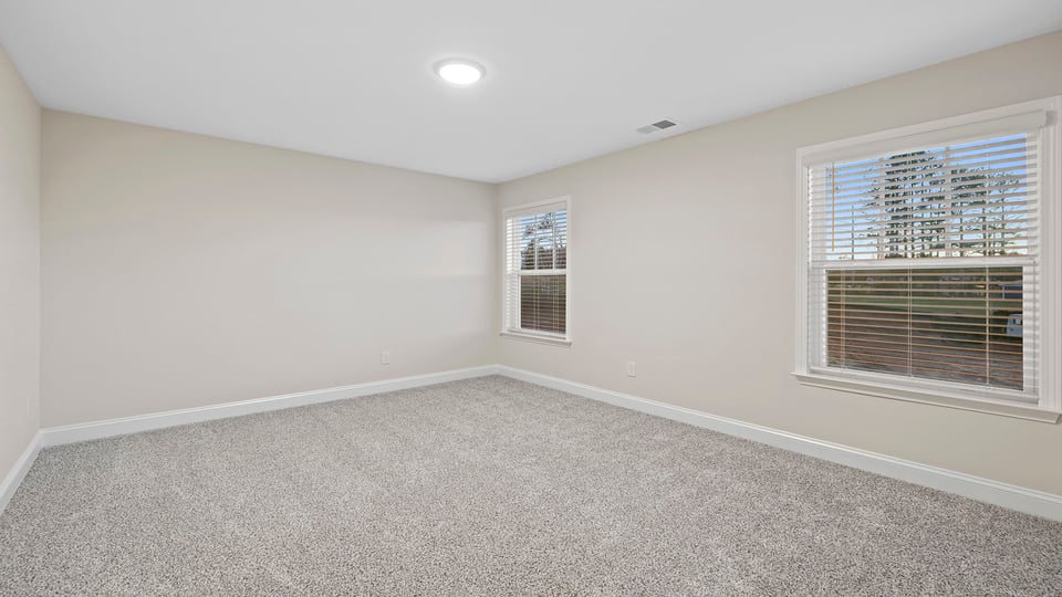 Bedroom with carpet and windows.