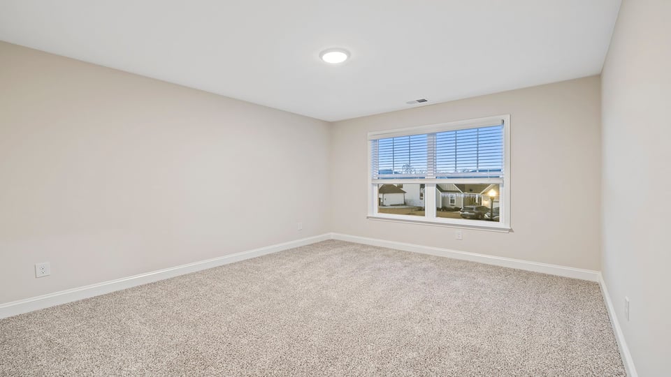 Bedroom with carpet and windows.