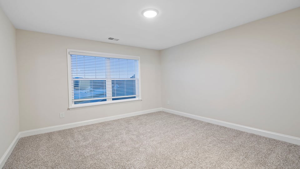 Bedroom with carpet and windows.