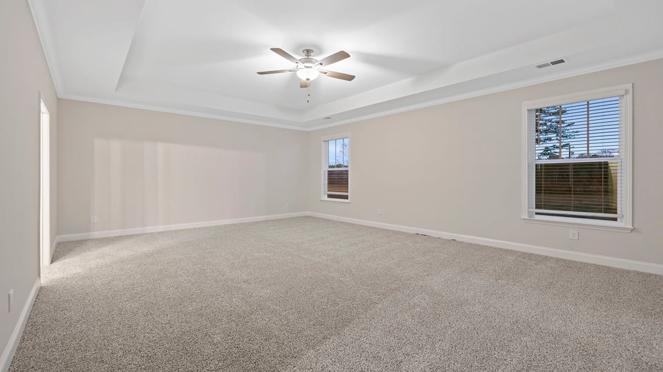 Bedroom with carpet and windows.