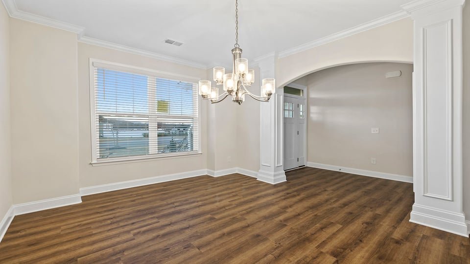 Dining room with chandelier and windows.