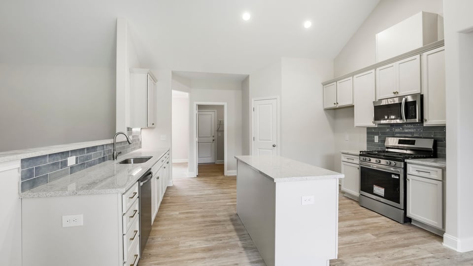 Kitchen and island with stainless steel appliances.