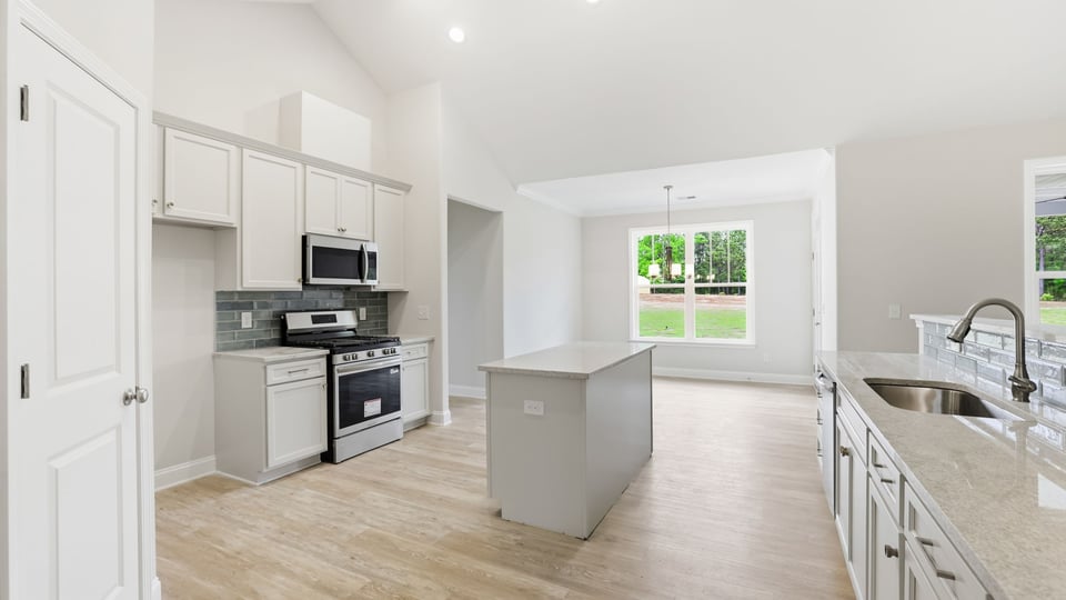 Kitchen and island with stainless steel appliances.