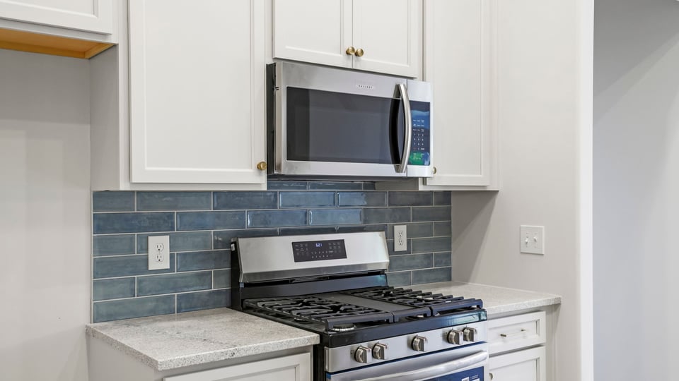 Kitchen and island with stainless steel appliances.