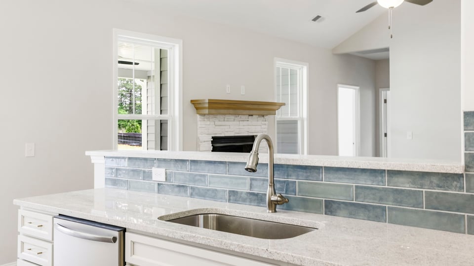 Kitchen and island with stainless steel appliances.