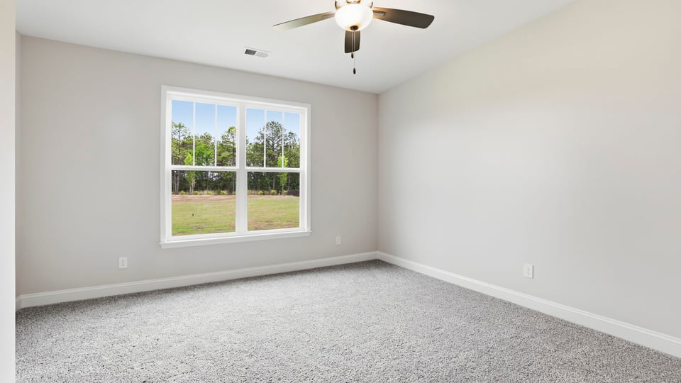 Bedroom with carpet and window.
