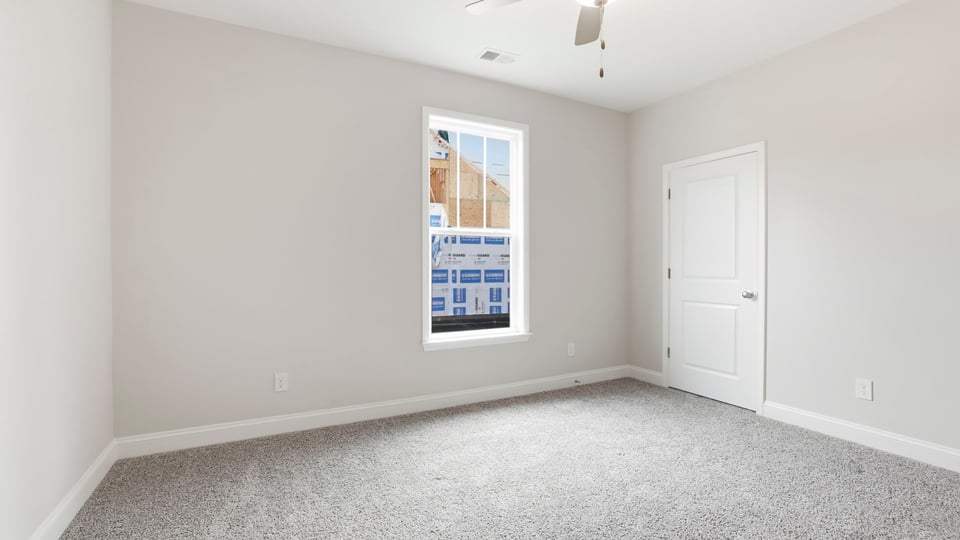 Bedroom with carpet and window.