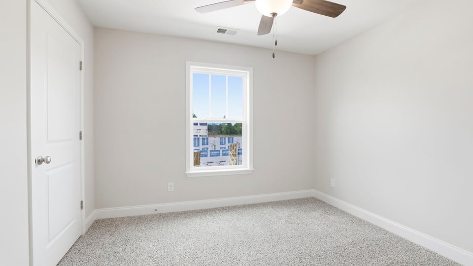 Bedroom with carpet and window.