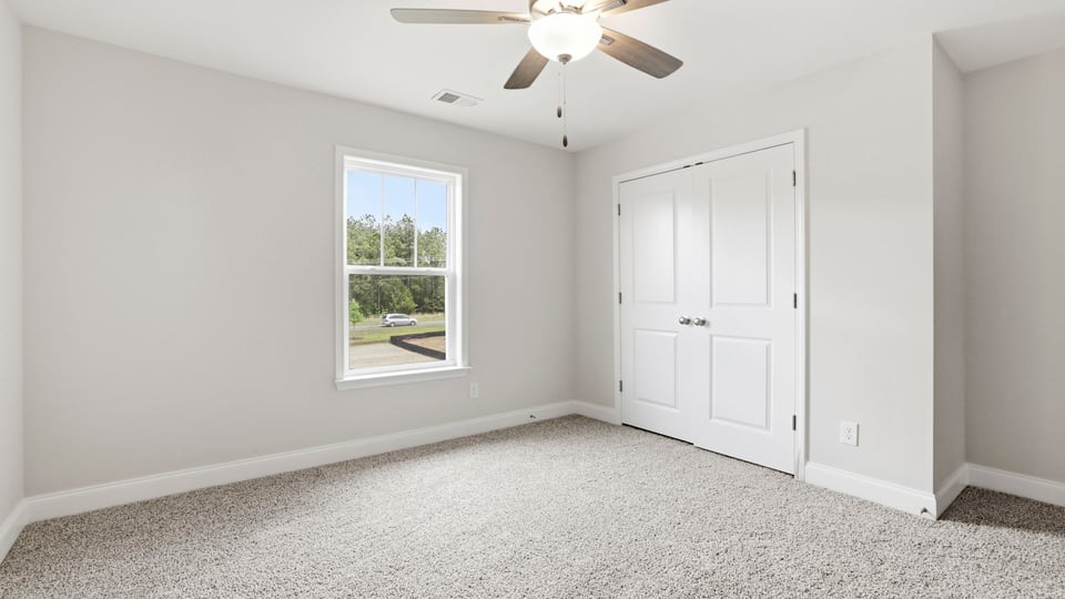 Bedroom with carpet and window.