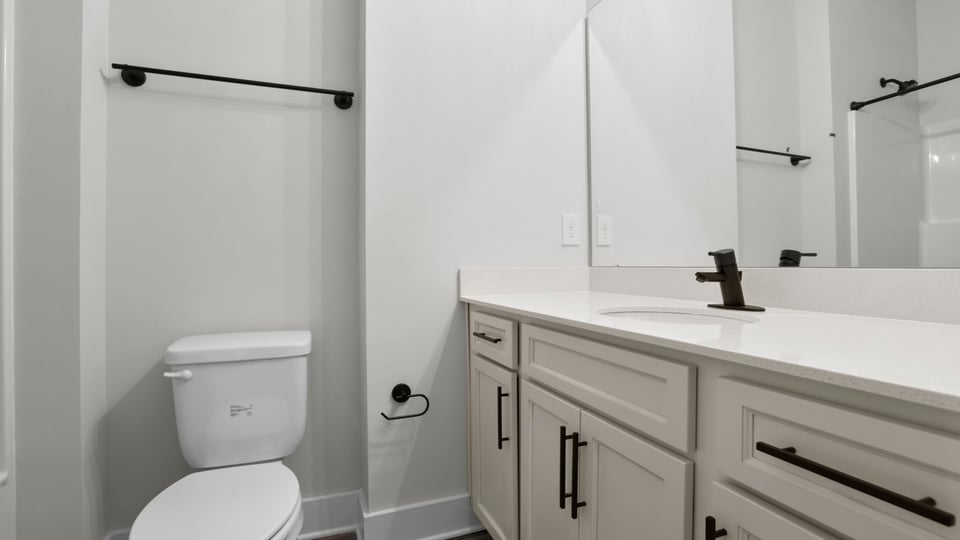 Bathroom with double vanity sink and toilet.