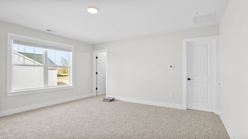 Bedroom with carpet and window.