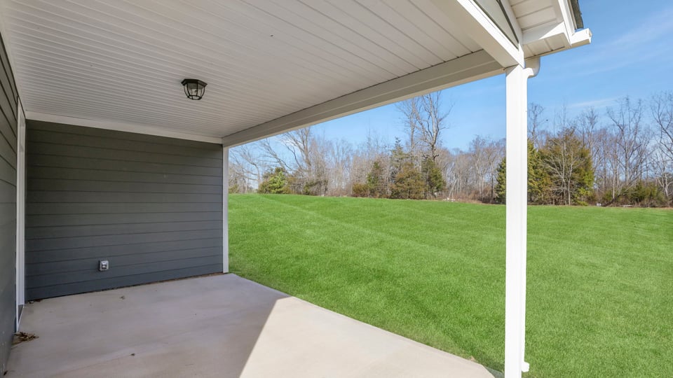 Back exterior of home with small patio.