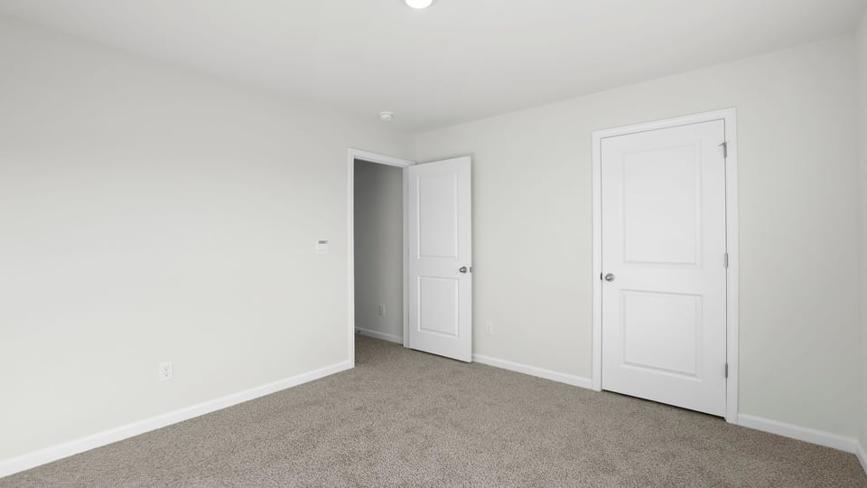 Bedroom with carpet and window.