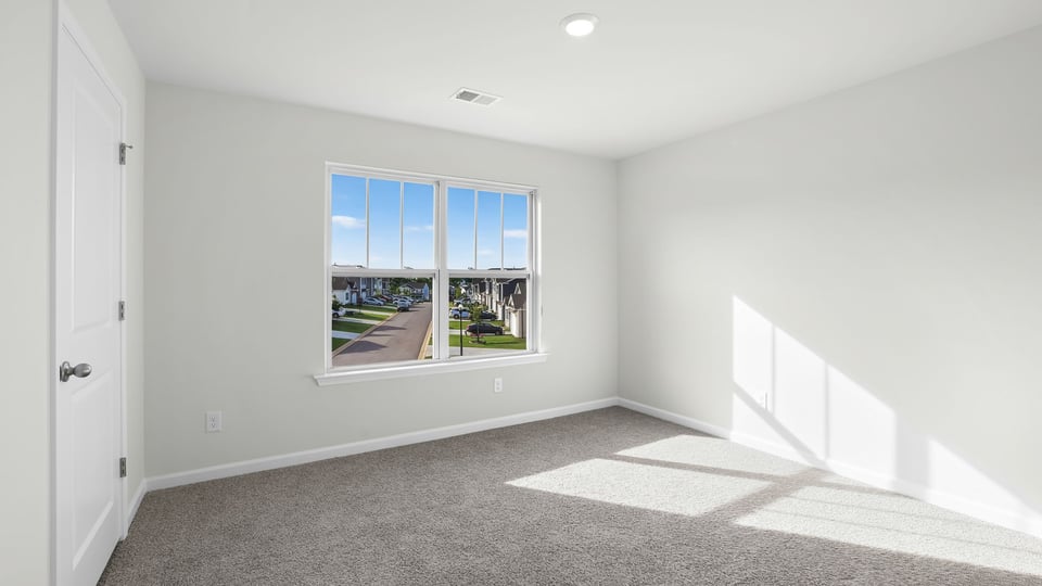 Bedroom with carpet and window.