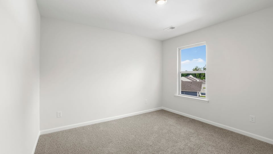 Bedroom with carpet and window.