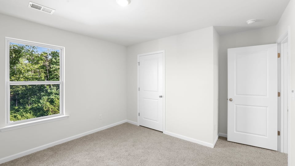 Bedroom with carpet and window.