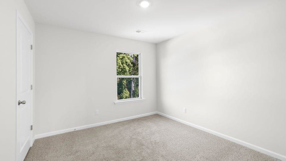 Bedroom with carpet and window.